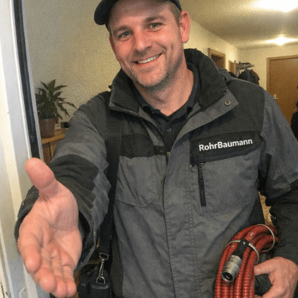 Installateur bespricht den Auftrag mit einer Kundin im Badezimmer neben dem Waschbecken